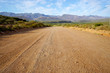 Long open dirt road in mountain landscape