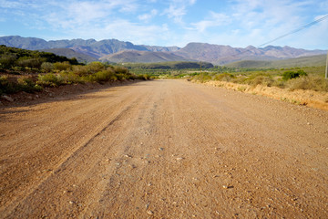 long open dirt road in mountain landscape