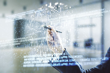 Poster - Double exposure of male hand with pen working with abstract virtual creative code skull hologram on blurred office background. Malware and cyber crime concept