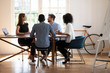 © fizkes - In board room gather multiethnic corporate staff communicating during morning briefing. Businesspeople planning, solving current issues. Negotiation between client and company managers process concept