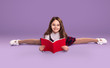 Flexible schoolgirl doing homework and smiling