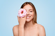 Cheerful bare shouldered woman with pink flower