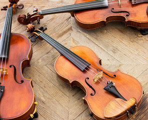 Violins on a wooden background. Two violins and viola.