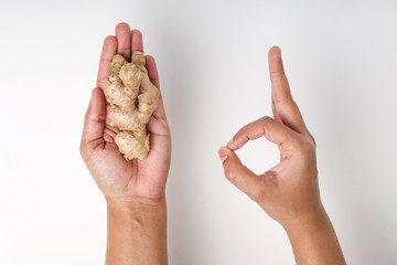 Fresh ginger in hand on white background, herb medical concept