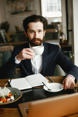 Wall Mural - Handsome man in a black suit. Businessman working in a office