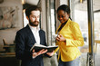 © prostooleh - Handsome man in a black suit. Woman in a yellow jacket. Businessman working in a office