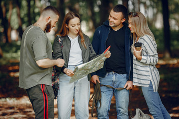 Tourists in a summer forest. Friends with a map.