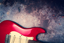 A Red Electric Guitar On A Grunge Background.