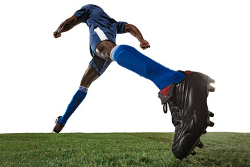 Wall Mural - Football or soccer player on white background with grass. Young male sportive model training, practicing. Attacking, catching. Concept of sport, competition, winning, motion, overcoming. Wide angle.