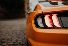 Rear Lights Of Orange Car On The Street From Behind With Copy Space