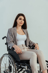 Disabled woman looking at camera on wheelchair isolated on white