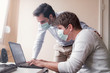 © Teodor Lazarev - Two businessmen with protective masks working from quarantine