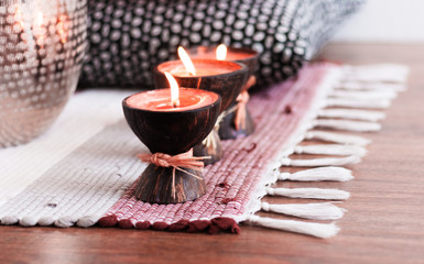 Wall Mural - Cozy home interior decor, spa aroma candles in coconut shell on a multi-colored rug .