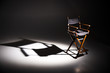 © Ivan - Directors chair stands in the beam of light. Space for text. Vacant chair. The concept of selection and casting. Shadow and light.