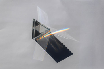 prism dispersing sunlight splitting into a spectrum on a white background.