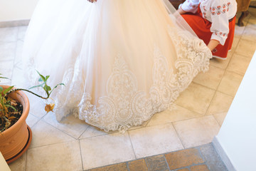 Wall Mural - bridesmaid helping bride with dress