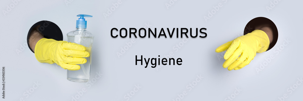 Hands in yellow gloves hold an antiseptic gel for hygiene through paper hole. Coronavirus prevention protective. Banner with text: Coronavirus. Concept. Safe shopping. - obrazy, fototapety, plakaty 