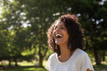 laughing young woman enjoying a sunny day in the park