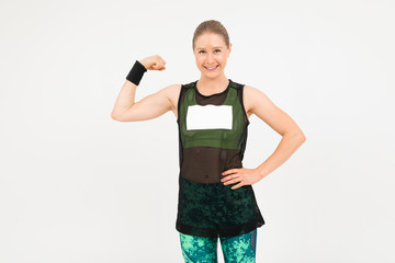 strong blonde girl in sportswear is engaged in fitness on a gray background