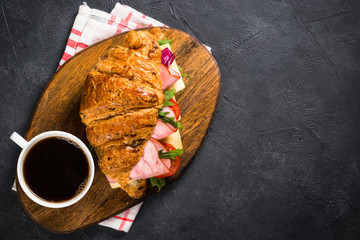 Canvas Print - Croissant sandwich on black table.