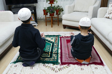 two Muslim children who worship prayer,