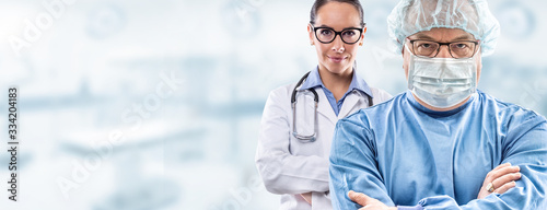 Cuadros en Lienzo Male mid age surgeon in glasses wearing blue dress, protective face mask and hat