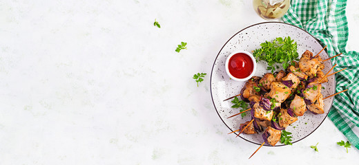 Grilled chicken kebab with red onions on a light table. Grilled meat skewers, shish kebab on light background. Top view, overhead, banner