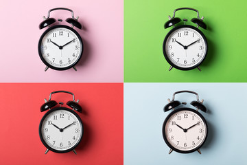 Wall Mural - Black vintage alarm clock on green, pink, red and blue backgrounds. Time concept