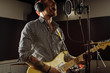 © alfa27 - professional caucasian singer play electric guitar in recording studio. man keen on rock and roll, enjoy performing music. music, instruments concept