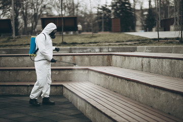 Wall Mural - Cleaning and Disinfection at town complex amid the coronavirus epidemic Professional teams for disinfection efforts Infection prevention and control of epidemic Protective suit and mask