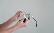 © mungkornz - girl hand cleaning glasses lens with white background, cleaning glasses concept.