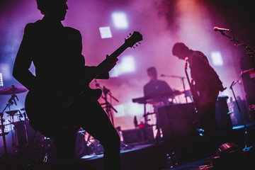 Blurred background light on rock concert with silhouette of musicians