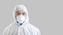 Asian Male Disinfector In Protective Mask, Suit And Glasses