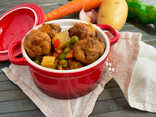 Canvas Print - Meatballs with potatoes and peas in a red casserole, carrot, tomato and potato