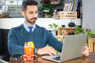 Wall Mural - Young handsome Businessman working on laptop in cafe.