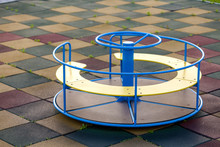 Playground In Kindergarten With Soft Flooring And Colorful Bright Merry-go-round Outdoors.