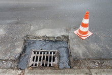 Road Construction, Road Rehabilitation, Asphalting. Holes And Damage On An Asphalt Road, Secured By Red And White Shut-off Cones Because Of The Risk Of Accidents