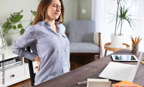 Fotografía Freelancer young woman suffering with back pain