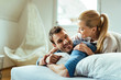 © Drazen - Young happy couple having fun while talking in bedroom.