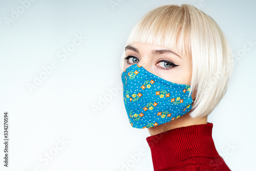 Woman wearing stylish handmade protective face mask. Fashion during quarantine of coronavirus outbreak. Copy, empty space for text