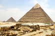 Giza Pyramids with stones and little beduin travelling on camel in front