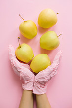 Hands In Pink Glove Holding Apples On Pink Background Flat Lay. Safe Shopping In Quarantine. Order Food Online With Delivery And Stay Home. Prevention Of Virus Epidemic. Stay Safe.