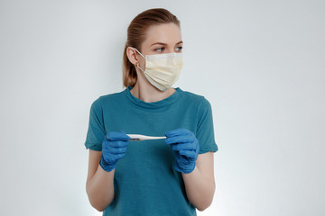 Young woman wearing medical face mask. High temperature in women. Signs of the virus.