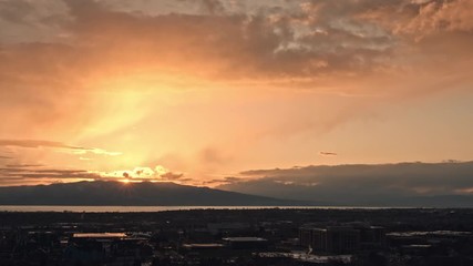 Wall Mural - Sunset time lapse as light rain falls from the sky over Provo as the clouds light up in vibrant colors.