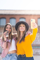 Wall Mural - Two Female Friends Taking a Selfie Outdoors.