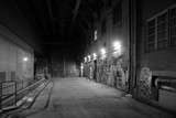 Fototapeta Uliczki - Depressing dark alley with graffiti in grayscale