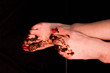 Girl's dirty bare feet stained with mud with painted red nails. On a black background