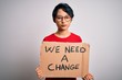 © Krakenimages.com - Beautiful asian girl protesting holding banner with change message over white background with a confident expression on smart face thinking serious
