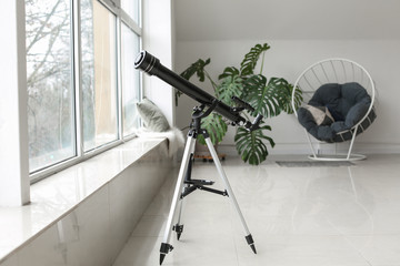 Modern telescope in interior of room