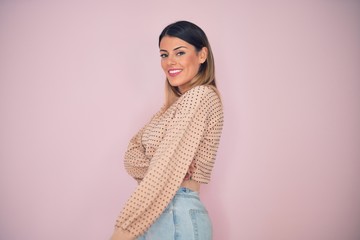 Sticker - Young beautiful woman wearing fashionable clothes smiling happy and confident. Standing with smile on face over isolated pink background